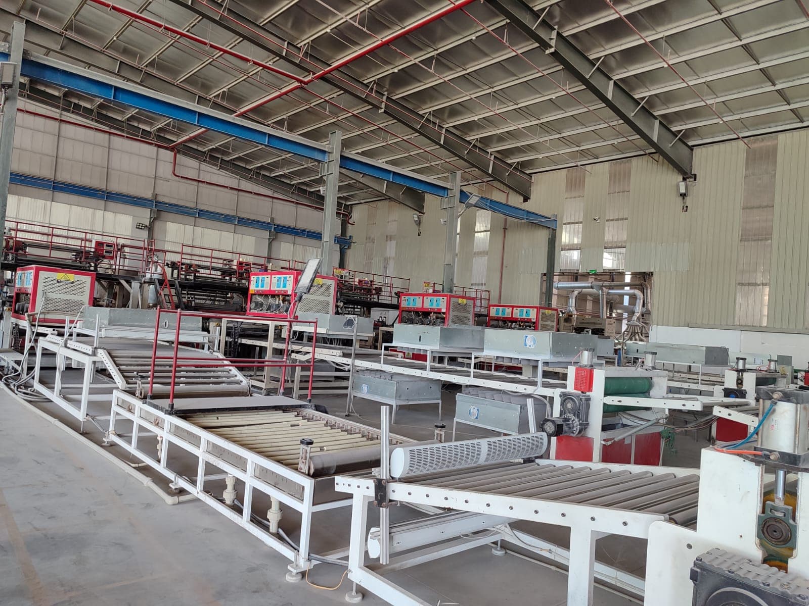Flooring production line with roller conveyors and machinery