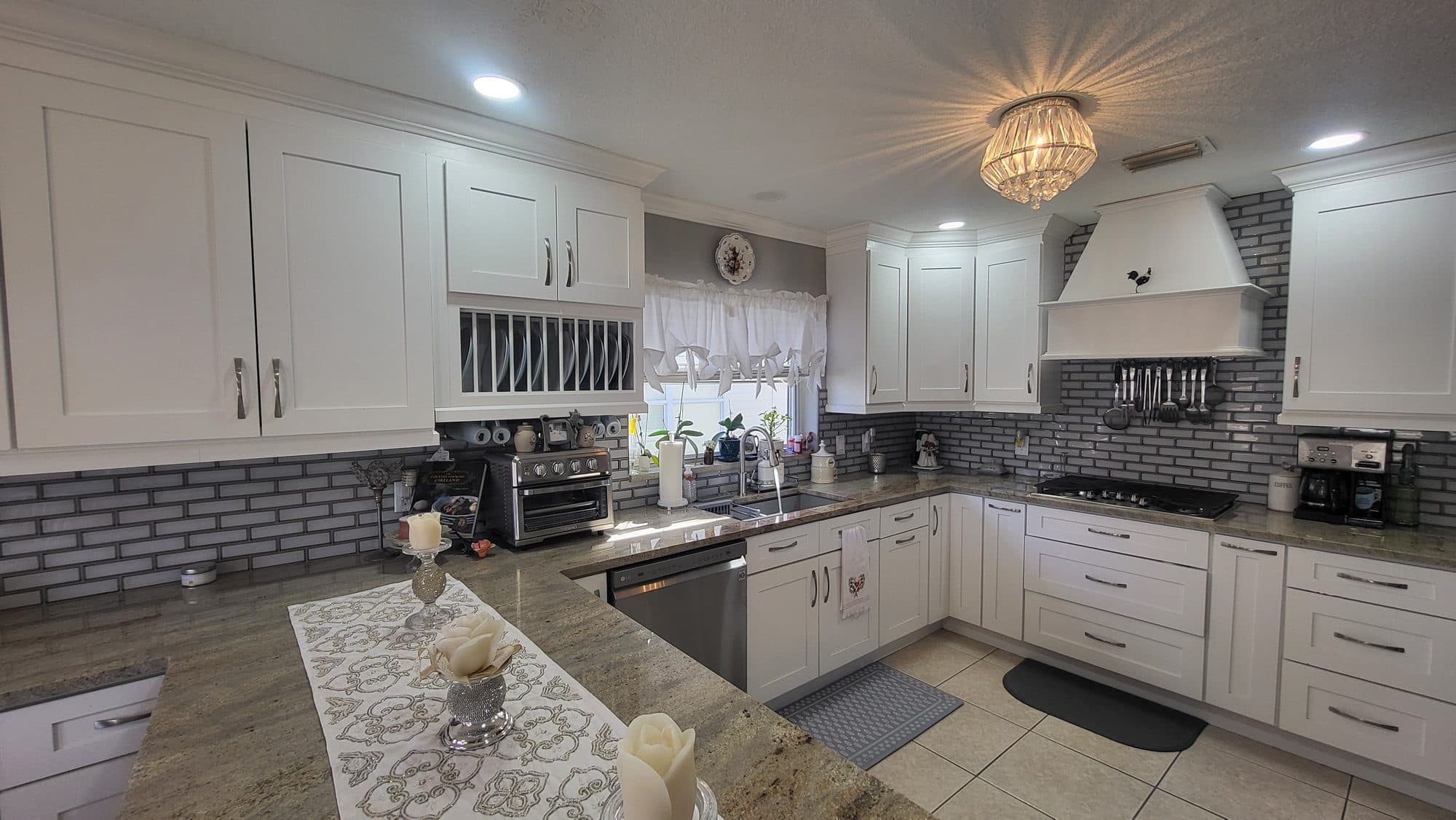 White Kitchen with Tile Backsplash and Range Hood