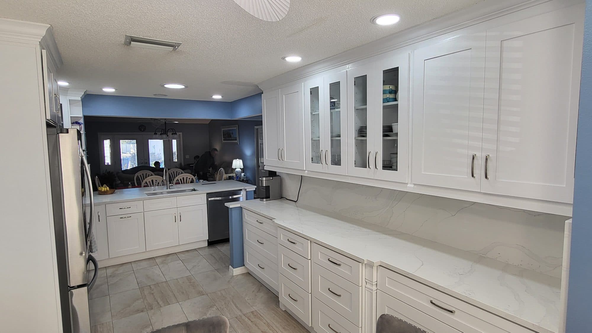 White Kitchen with Louvered Doors and Glass Uppers