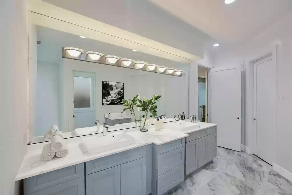 Grey shaker spa-style vanity with marble walls