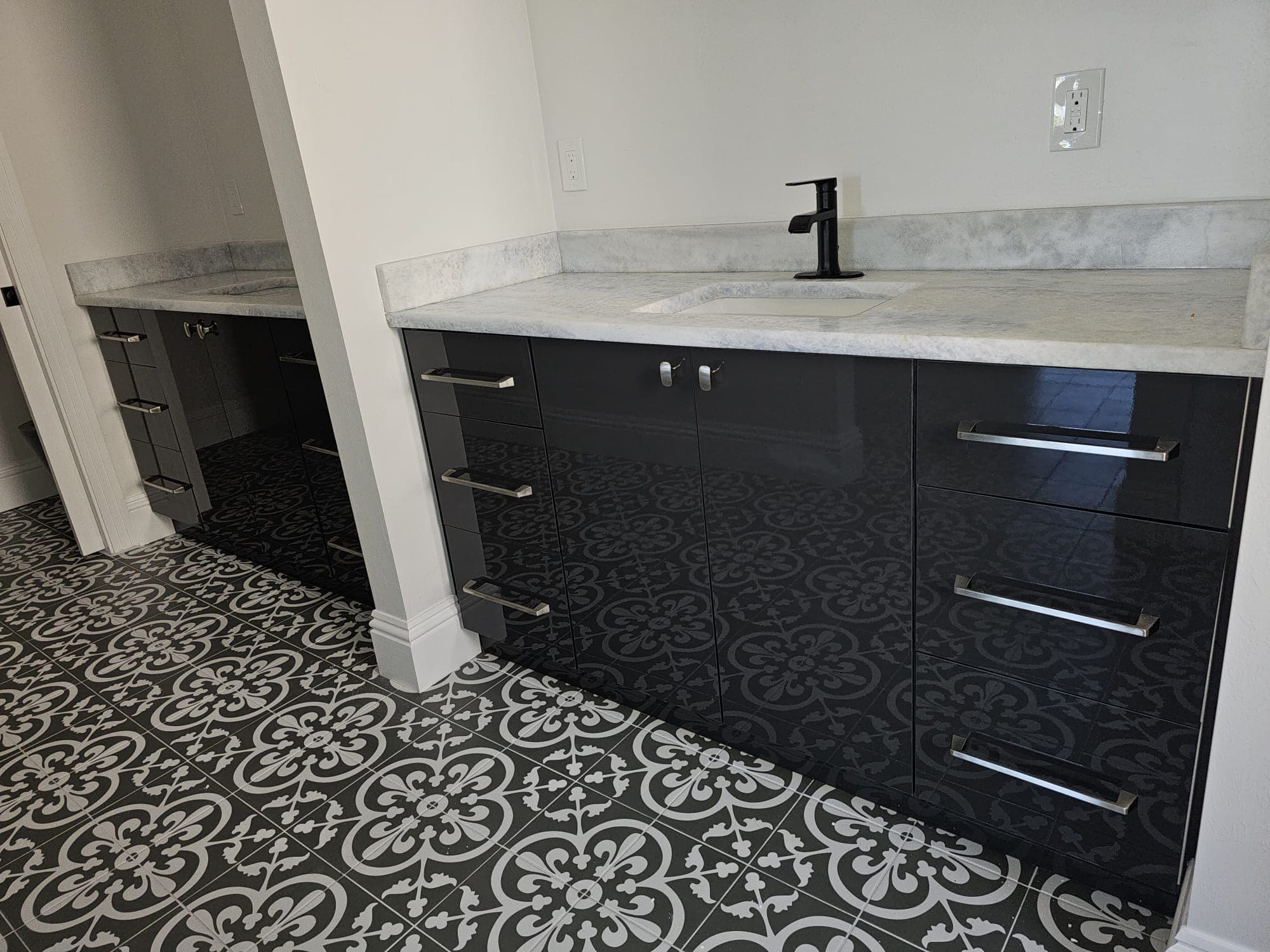 Black high-gloss vanity with decorative tile floor